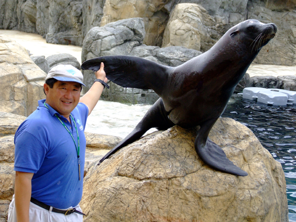 Hugh and Parker the sea lion holding hands