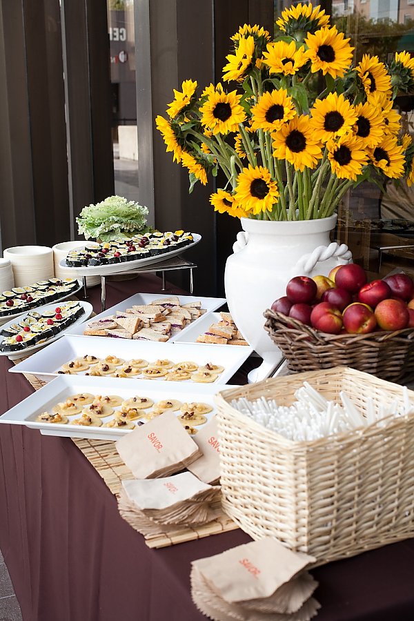 Buffet table with different foods and sunflowers in a vase