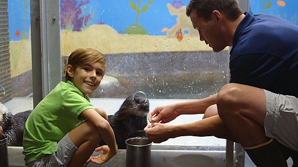 Boy with otter and trainer