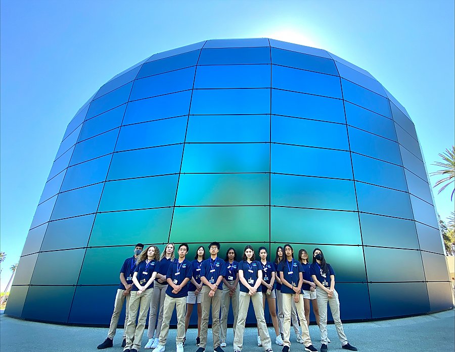 Group of teen volunteers pose in front of the Pacific Visions building