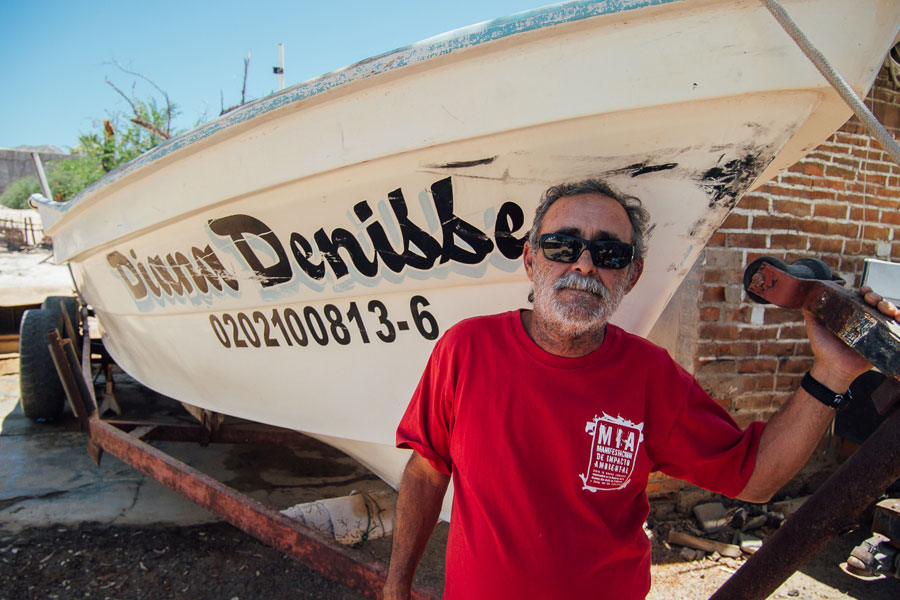 Fisherman José Luis “Chalunga” Romero González standing next to his boat