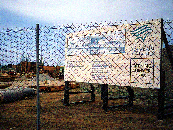 Aquarium sign behind a fence in a lot under construction