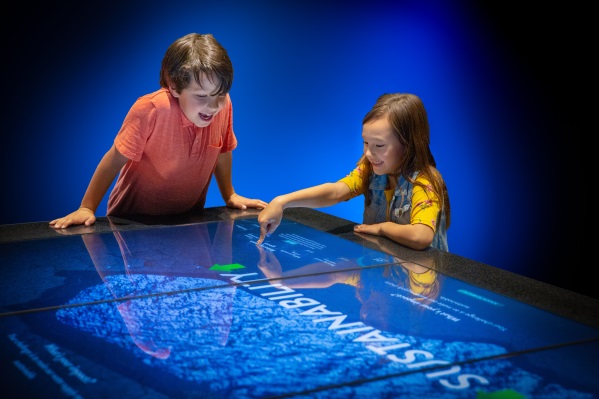 Boy and girl gesture with interactive table