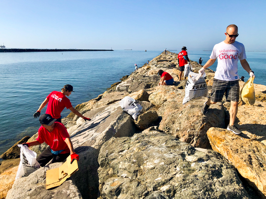 People cleaning up trash on the breakwater.
