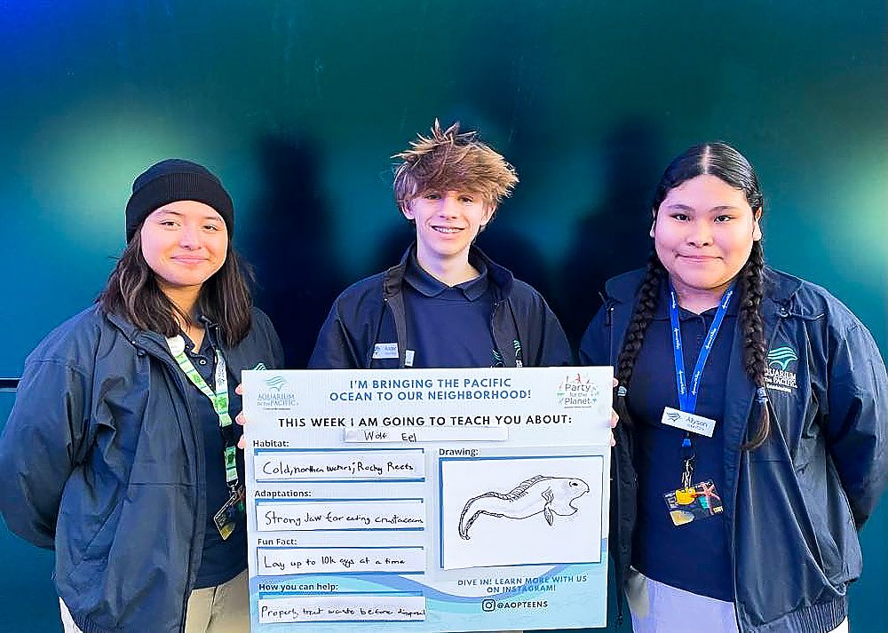 Ocean Neighbors teenagers holding signs they created to raise awareness about ocean
                      species