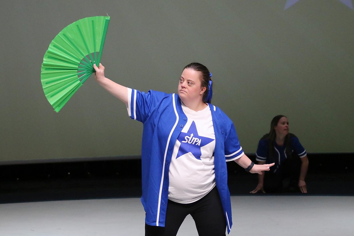 Woman performing with a green fan on stage