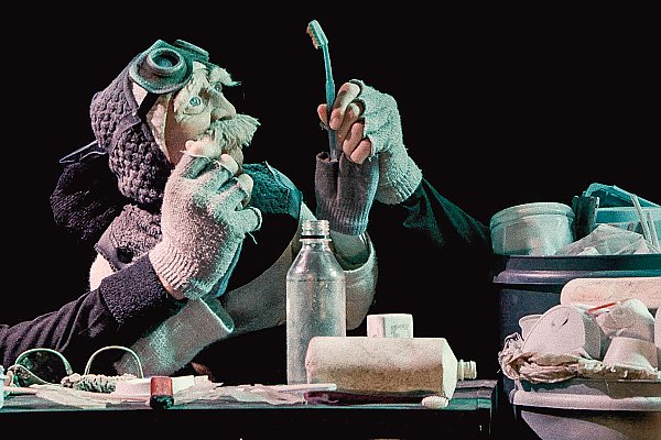 Still from the film featuring a puppet and various items of plastic trash.