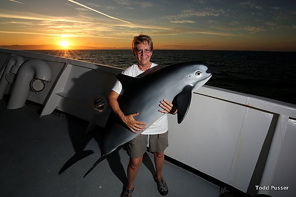 Woman on a boat holding a vaquita model