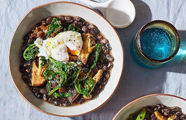 Bowl of beans, mushrooms, spinach, topped with a poached egg as seen on the cover of