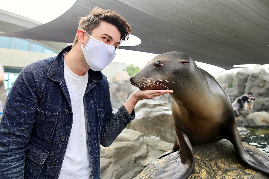 Masked young man poses with a sea lion