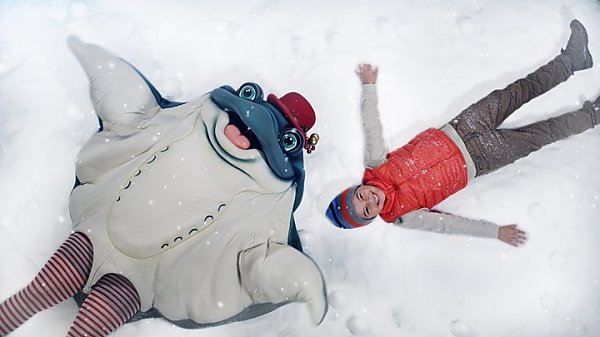 Ray mascot and boy make snow angels