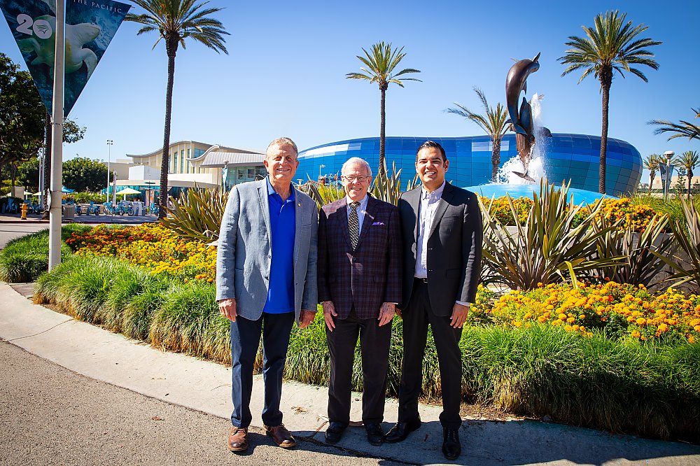 Frank Colonna, Jerry Schubel, and Mayor Robert Garcia stand in front of the Aquarium with the Pacific Visions wing in the background.