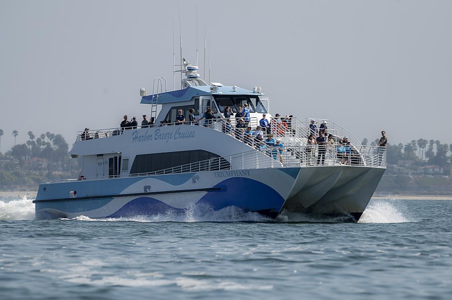 A catamaran boat with the text Harbor Breeze on the side on the ocean