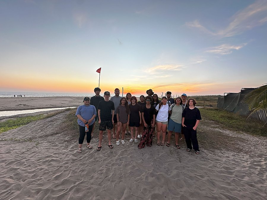 A group of teens gathered on a beach