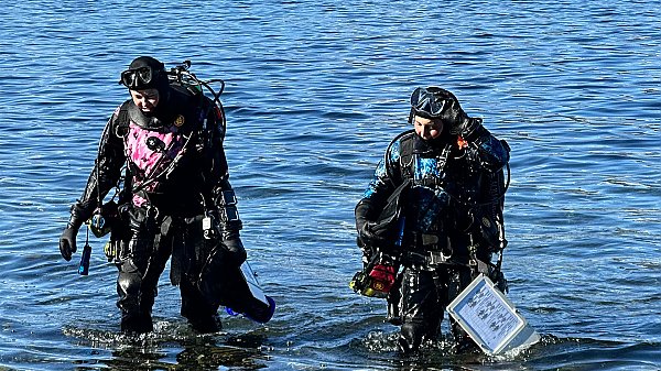 two SCUBA divers standing in shallow water