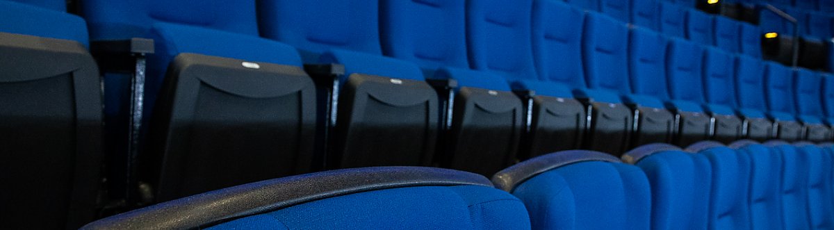 Row of empty blue seats in theater - Hero promo