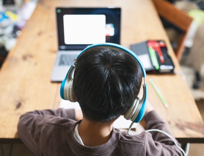 Boy with headphones looking at laptop