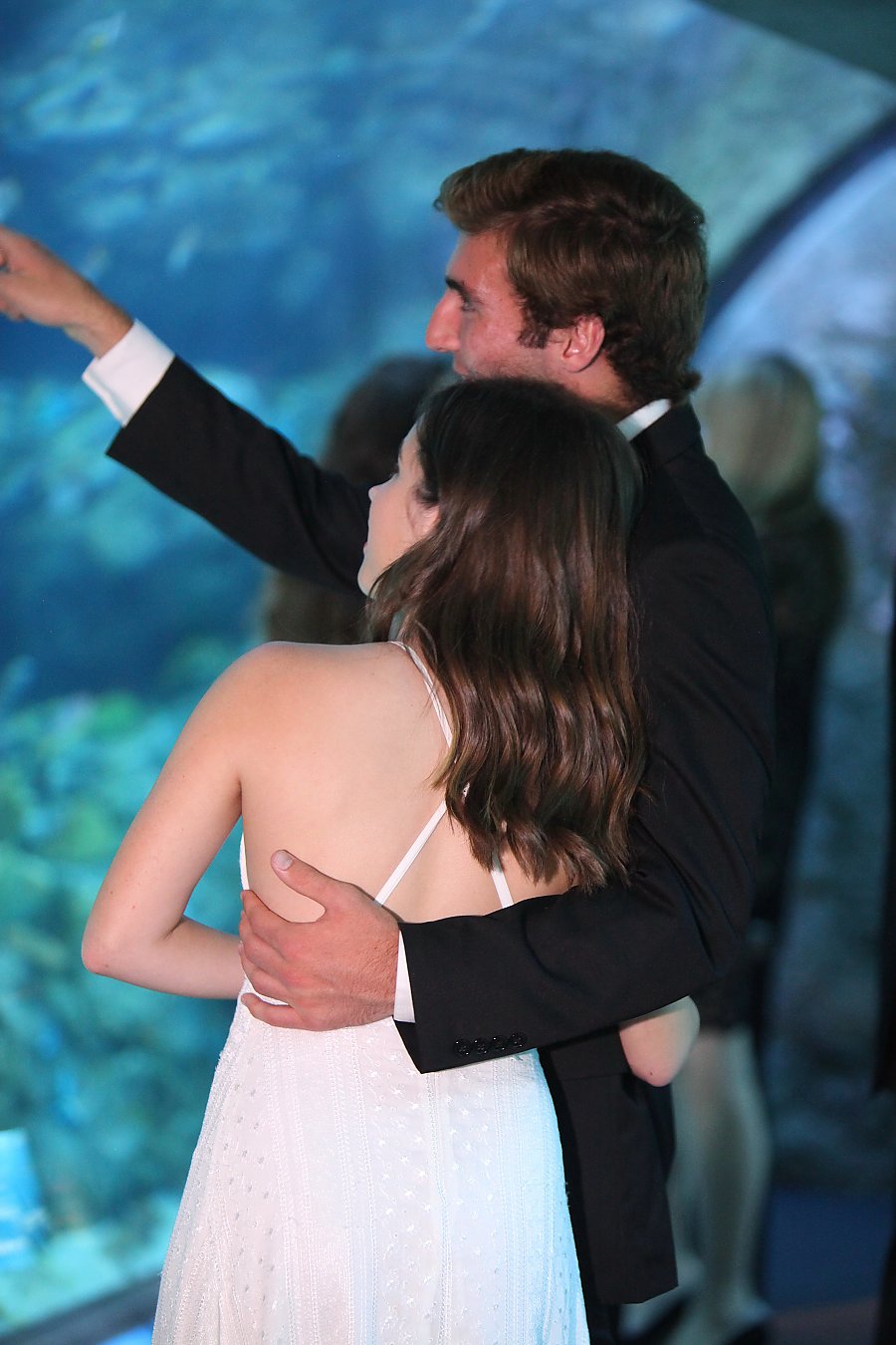 Man and woman in formal wear looking at fish tank