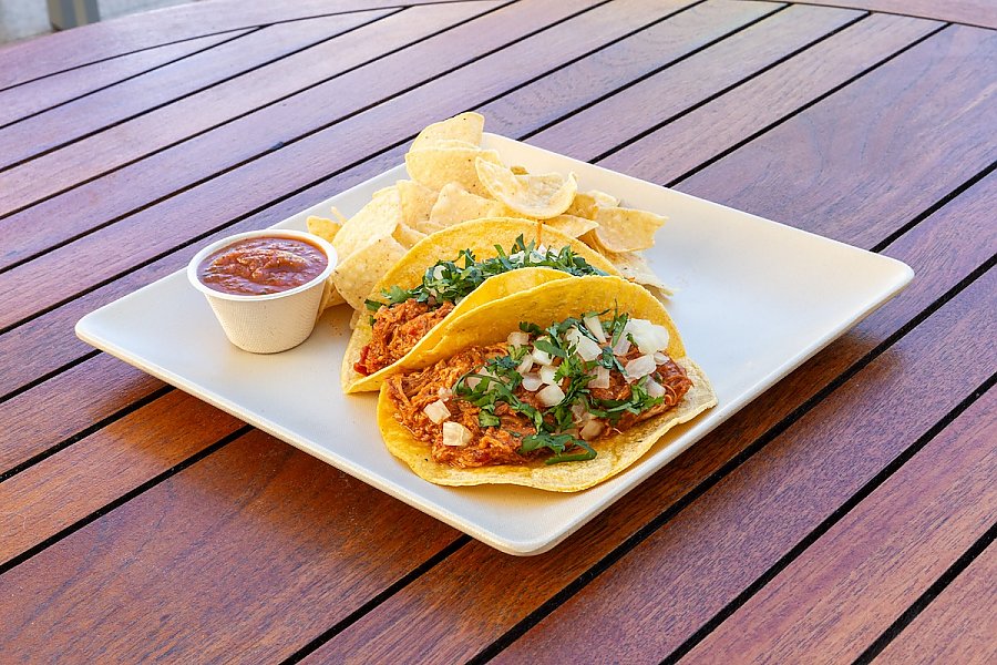 two tacos on a plate with chips and salsa