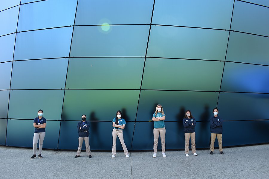 Teen volunteers pose against Pacific Visions