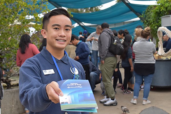 Aquarium Volunteer holding Visitor Guide