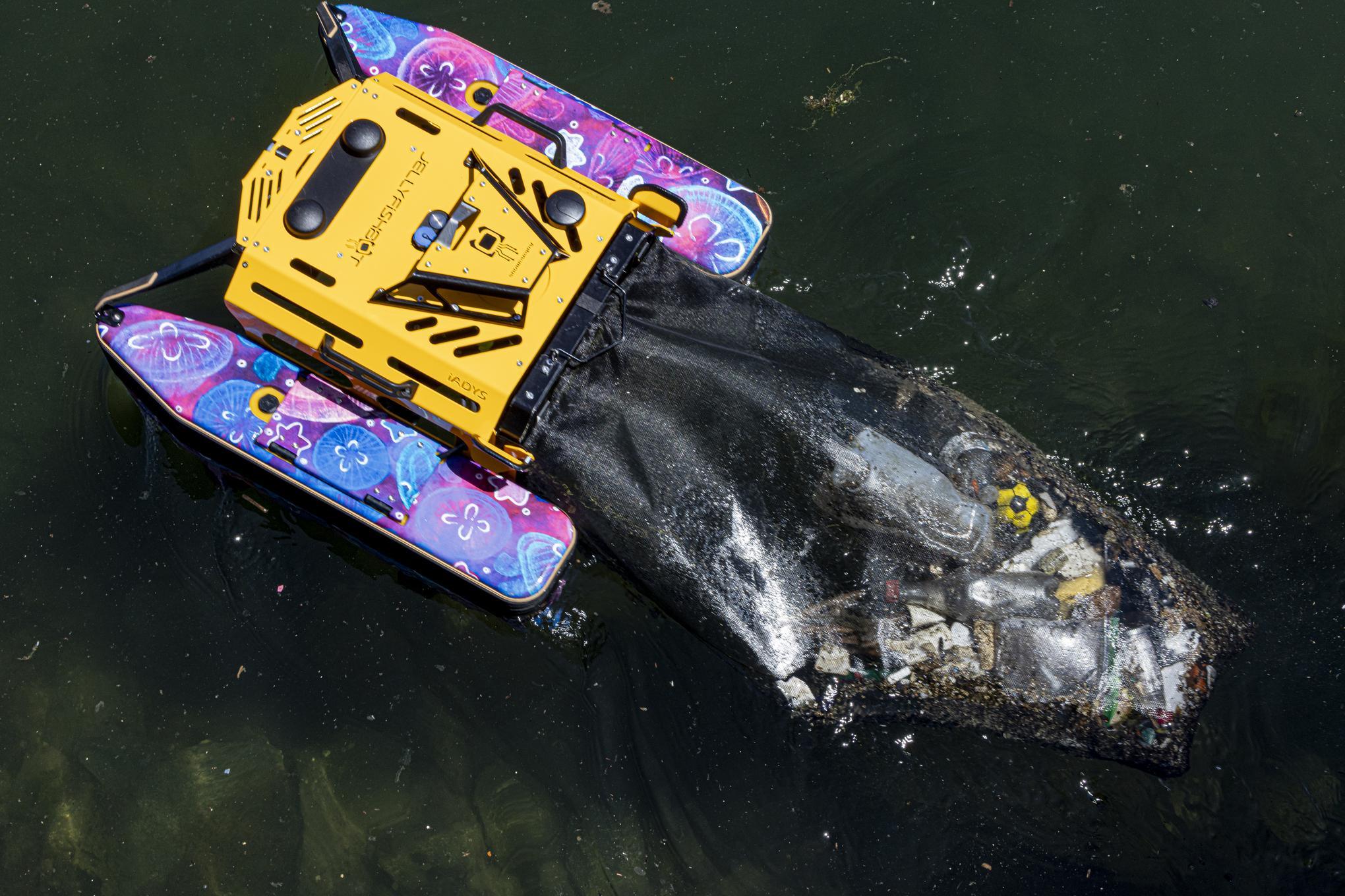 A small, multi-colored device dragging a net with debris