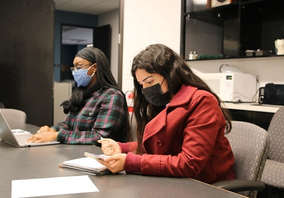 Elishebah Tate-Pulliam and Desiree Felix compile data for wolf research.