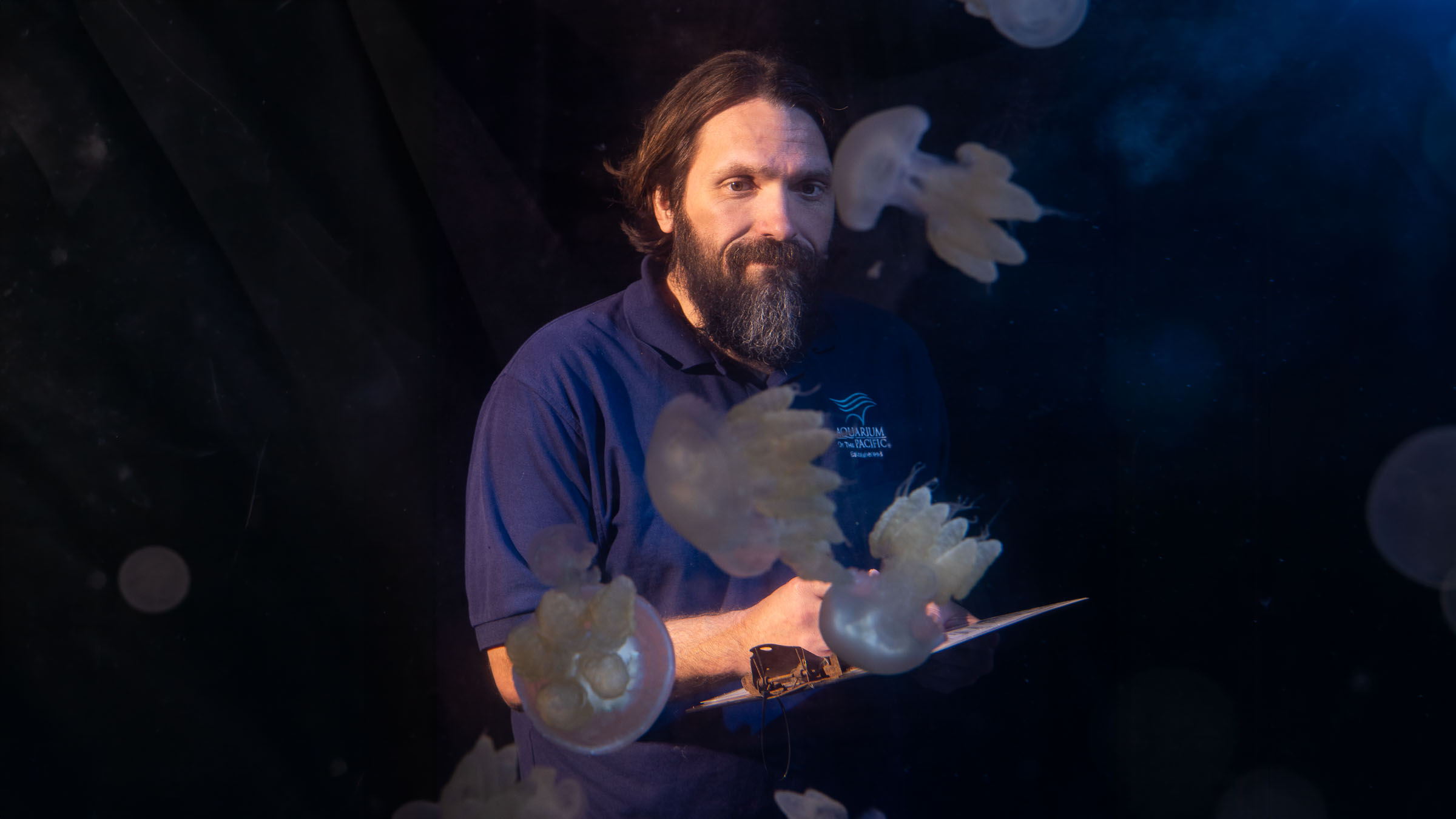 husbandry staff Josh Wagner with clipboard assessing jellies