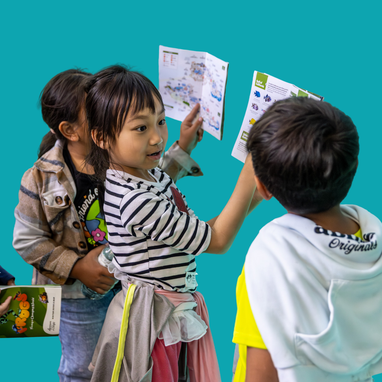 kids with visitor guide blue cavern teal background