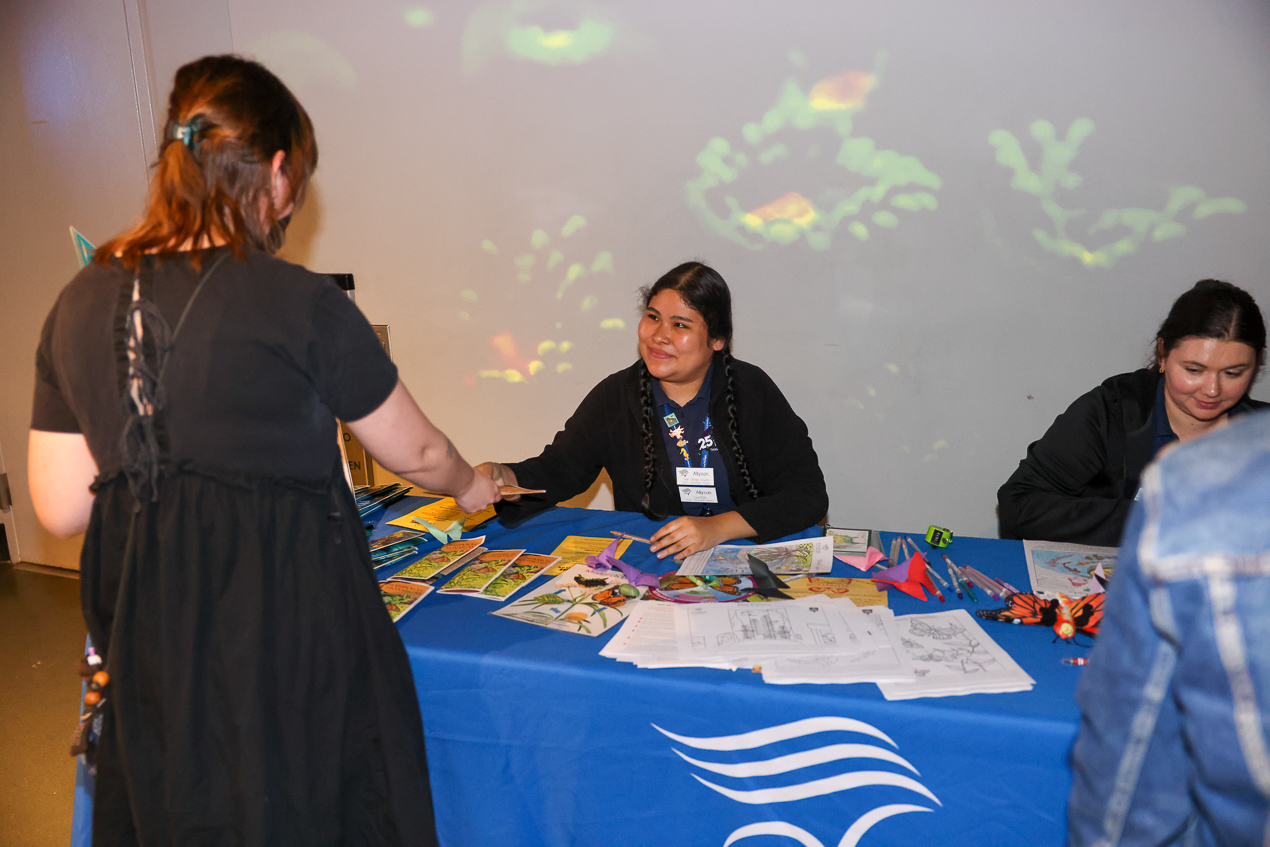staff volunteers at a table helping guest