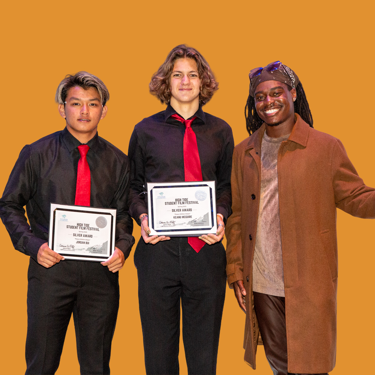 three people in a group two holding awards