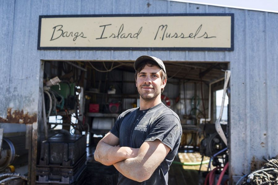 Headshot of farmer Matt Moretti in front of the dockside facility for Bangs Island Mussels.